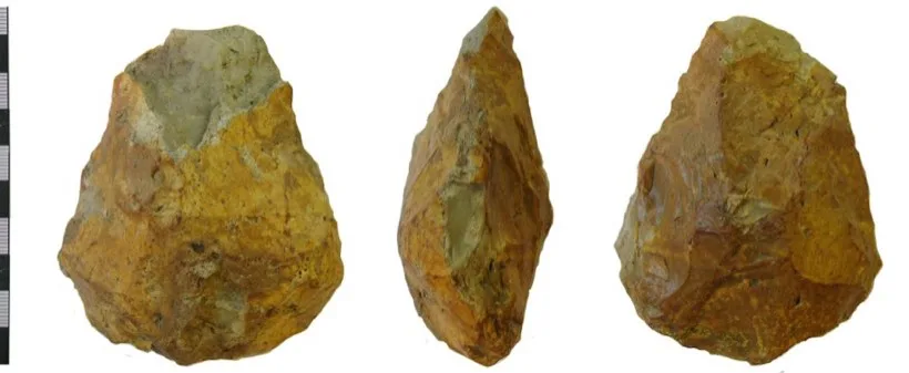 A teardrop-shaped flint handaxe photographed from the front, the side and the back, beside a scale bar.