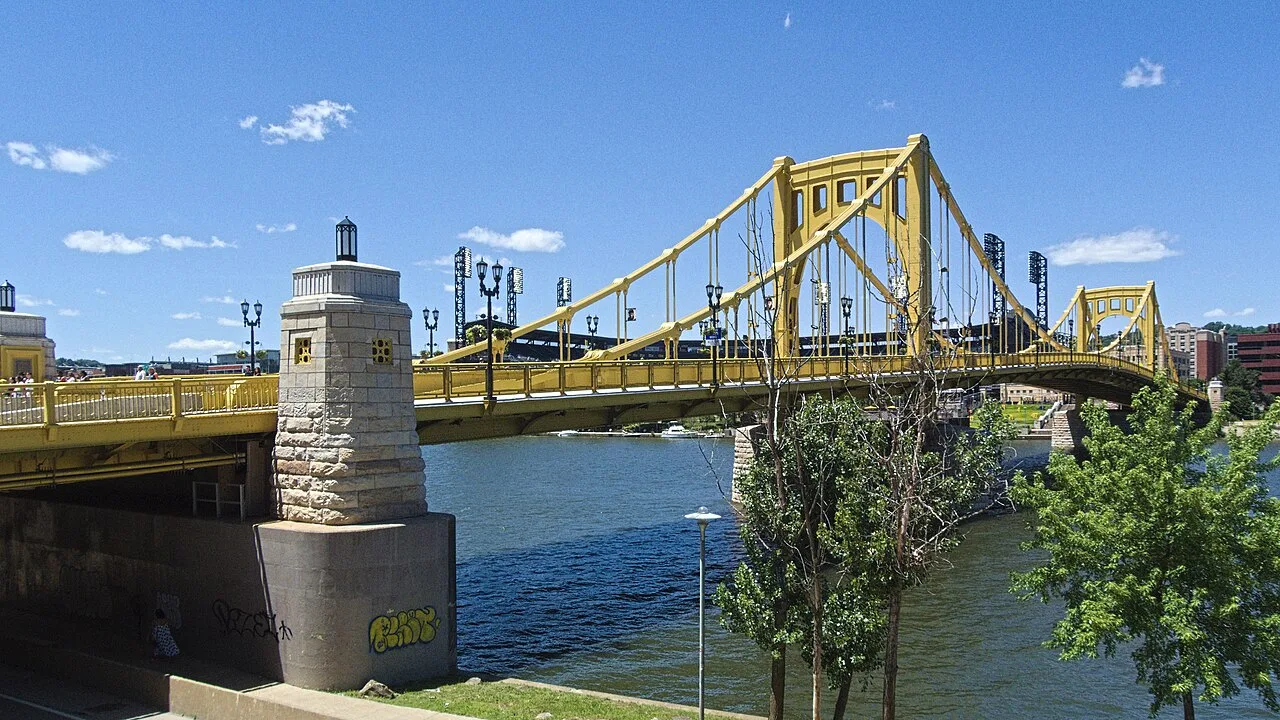 The yellow Roberto Clemente Bridge crossing the river in Pittsburgh